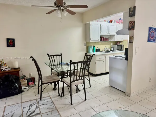a kitchen with stainless steel appliances a white table chairs and a refrigerator