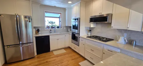 a kitchen with stainless steel appliances a refrigerator stove and sink