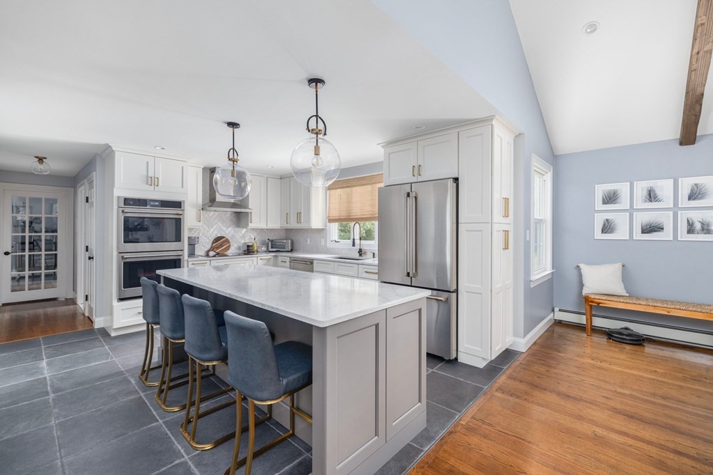 164 Rocky Hill Road Rehoboth, MA 02769 - Photo 19 of 42 a kitchen with stainless steel appliances a dining table chairs refrigerator and sink