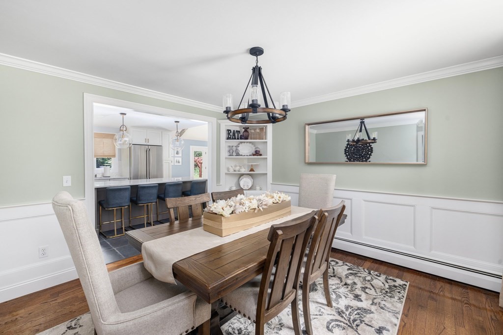 164 Rocky Hill Road Rehoboth, MA 02769 - Photo 24 of 42 a dining room with wooden floor a chandelier a wooden table and chairs