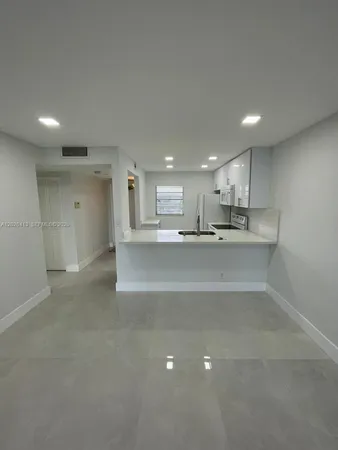 a large kitchen with kitchen island a sink stainless steel appliances and cabinets