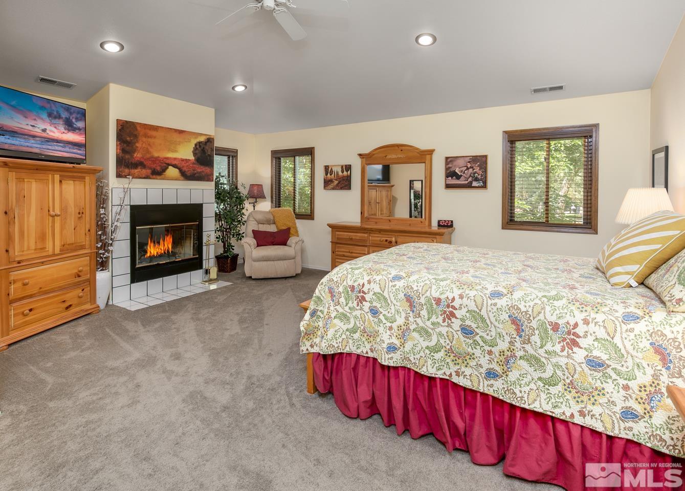 5586 Rivers Edge Drive Fallon, NV 89406 - Photo 17 of 40 a spacious bedroom with a bed and fireplace
