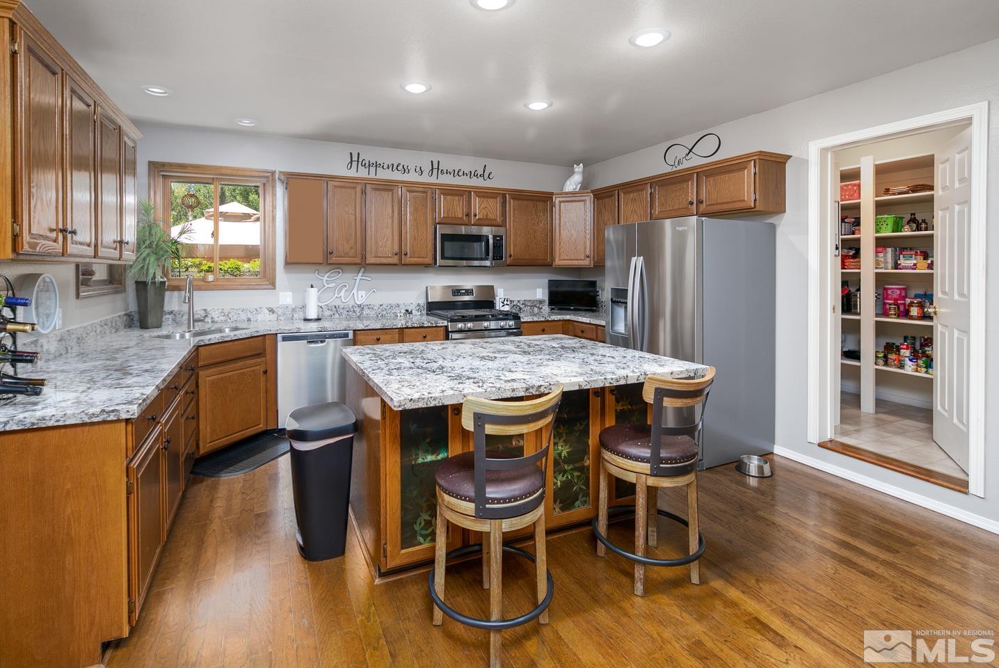 5586 Rivers Edge Drive Fallon, NV 89406 - Photo 8 of 40 a kitchen with granite countertop kitchen island stainless steel appliances a sink and a refrigerator