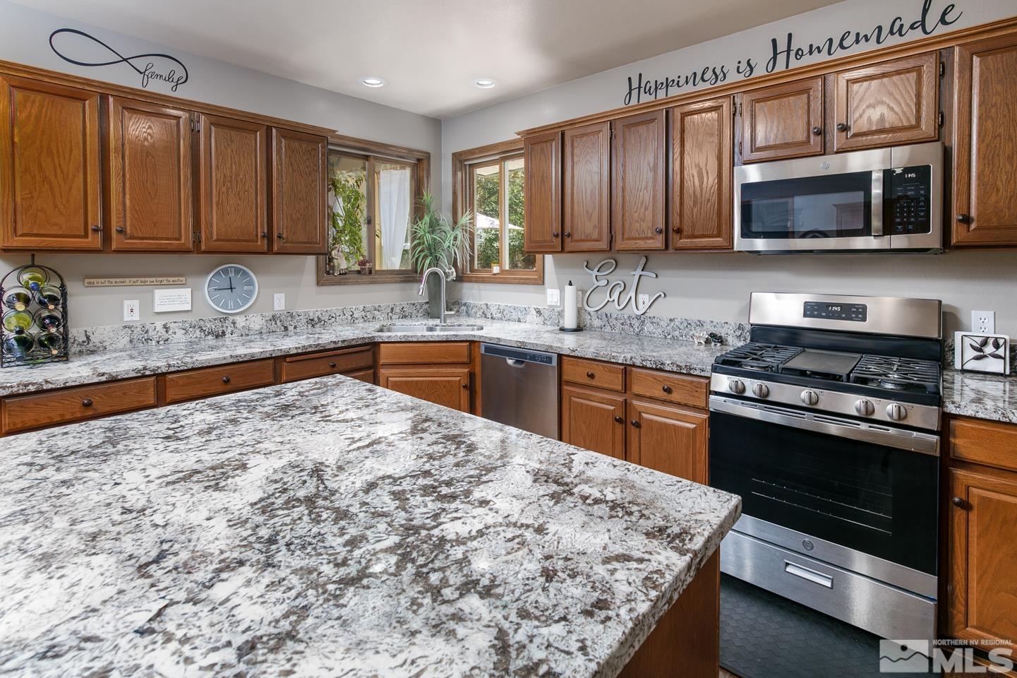 5586 Rivers Edge Drive Fallon, NV 89406 - Photo 10 of 40 a kitchen with stainless steel appliances granite countertop wooden cabinets a stove top oven a sink and dishwasher