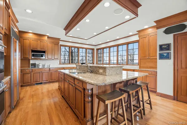 a kitchen with stainless steel appliances granite countertop table chairs sink and cabinets