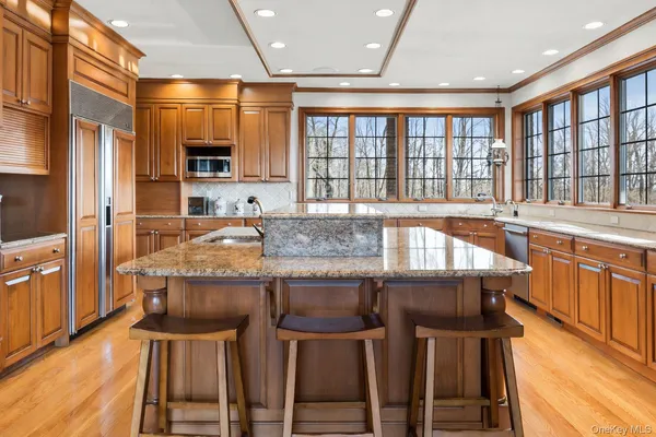 a kitchen with stainless steel appliances granite countertop a stove a sink and a refrigerator