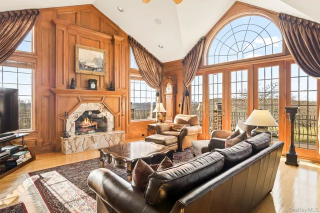 a living room with furniture a fireplace and a large window
