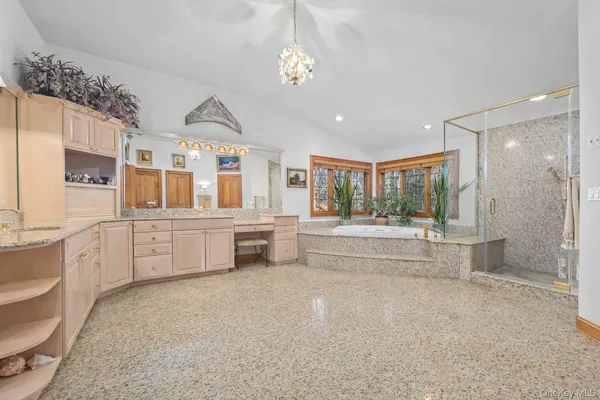 a large white bathroom with double vanity sink a bathtub and shower