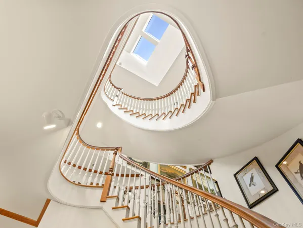 a view of staircase with railing and white walls