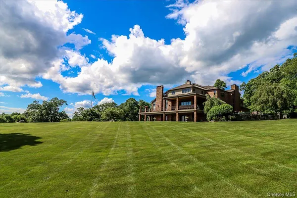 a view of a green field with house in the background