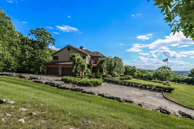 a view of a house with a big yard and large trees