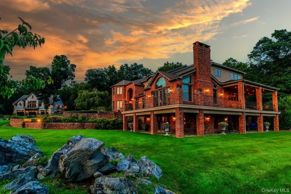 a view of a house with a big yard and large trees