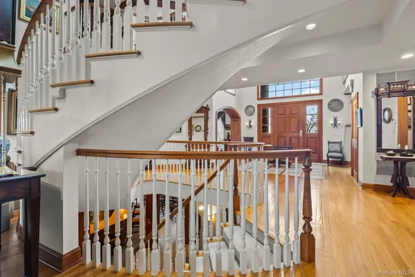 a view of staircase with white walls and a chandelier