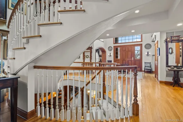 a view of staircase with white walls and a chandelier