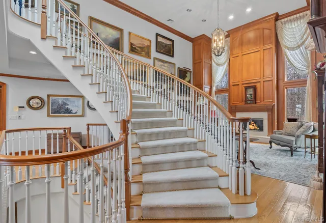 a view of staircase with lots of frames on wall and a large window