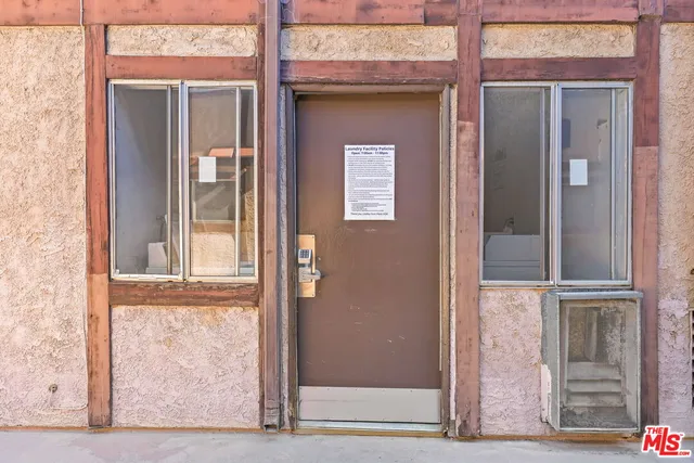 a front view of a building with a garden and plants