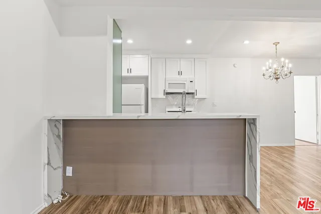 a view of a kitchen with cabinets and wooden floor
