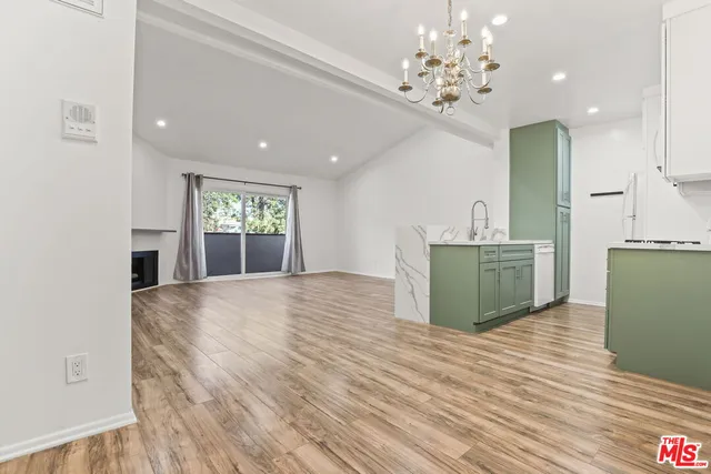 a view of kitchen with granite countertop cabinets and entryway