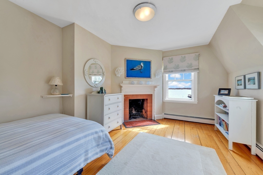 73-75 Harbor Street Manchester, MA 01944 - Photo 24 of 39 a bedroom with a bed and a fireplace