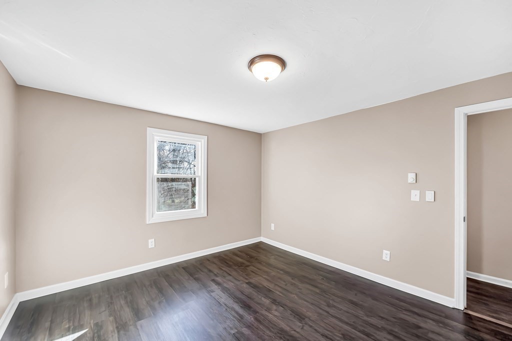 9 Hillside Road Leicester, MA 01611 - Photo 14 of 42 a view of an empty room with wooden floor and a window