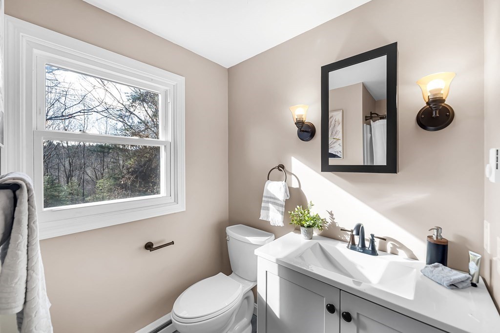 9 Hillside Road Leicester, MA 01611 - Photo 15 of 42 a bathroom with a toilet a sink a window and mirror