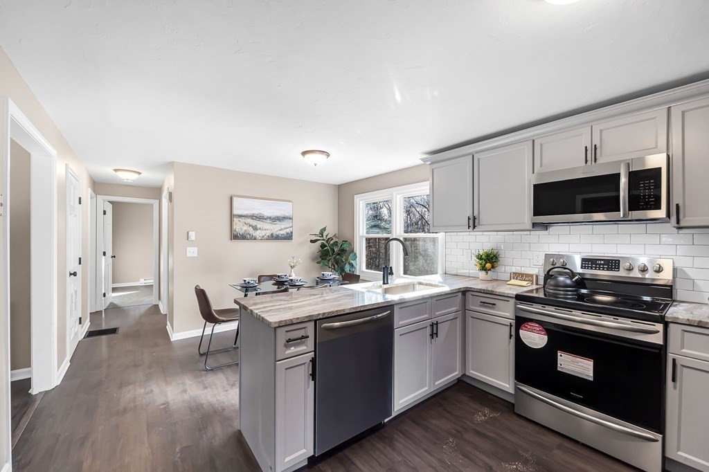 9 Hillside Road Leicester, MA 01611 - Photo 7 of 42 a kitchen with stainless steel appliances granite countertop a stove top oven a sink dishwasher and a microwave oven with wooden floor