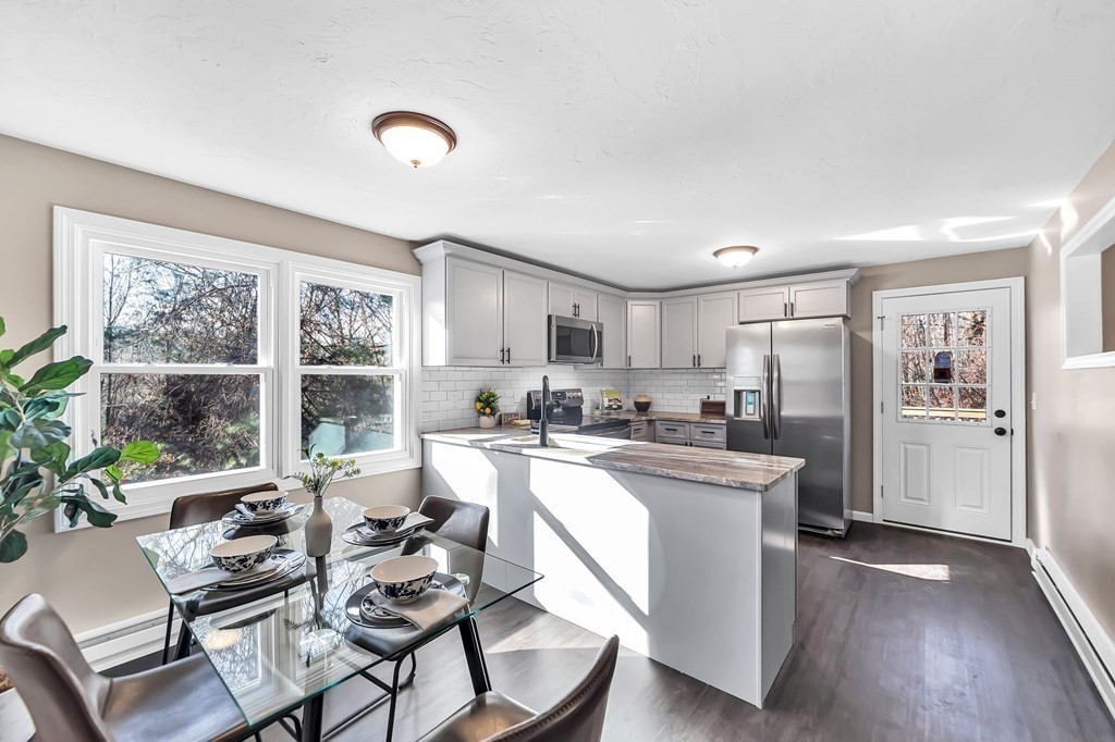 9 Hillside Road Leicester, MA 01611 - Photo 10 of 42 a kitchen with a table chairs refrigerator and wooden floor