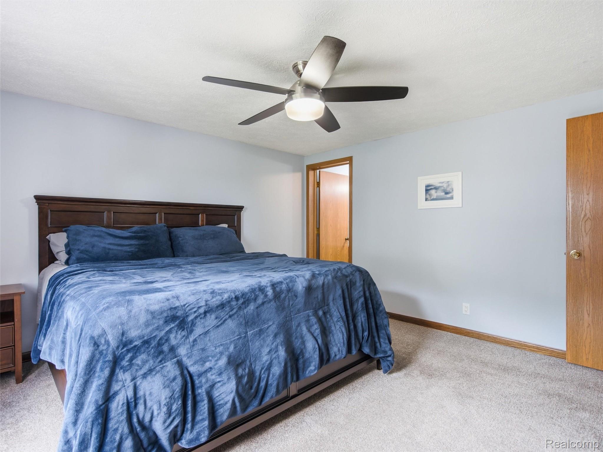 5003 Mason Road Howell, MI 48843 - Photo 19 of 59 Carpeted room featuring light blue walls, wood-finish baseboards, and a ceiling fan with integrated lighting
