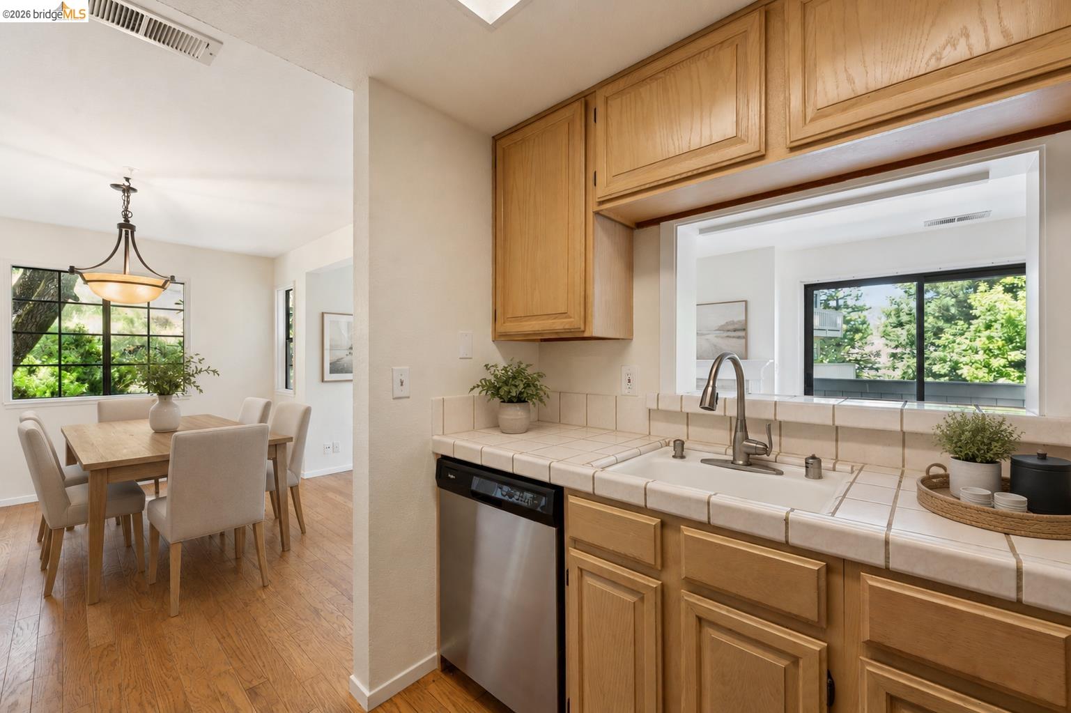 261 Redhawk Road Novato, CA 94949 - Photo 21 of 44 Kitchen featuring light wood cabinetry, white tile countertops, and a stainless steel dishwasher