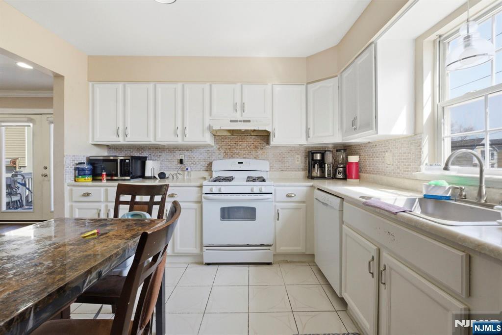 56 Lentz Avenue Newark, NJ 07105 - Photo 19 of 50 a kitchen with cabinets appliances a sink and a counter top space