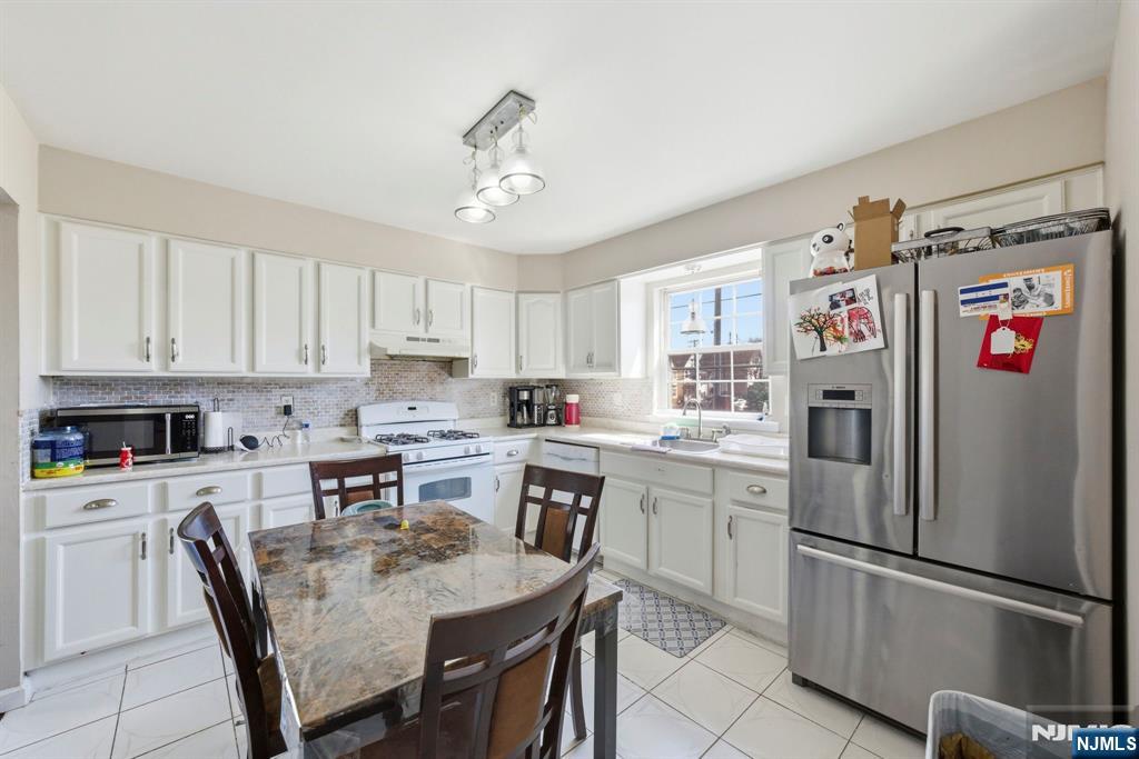 56 Lentz Avenue Newark, NJ 07105 - Photo 21 of 50 a kitchen with granite countertop stainless steel appliances a refrigerator a stove a sink and cabinets