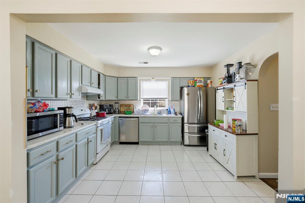 56 Lentz Avenue Newark, NJ 07105 - Photo 39 of 50 a kitchen with stainless steel appliances a refrigerator sink and cabinets