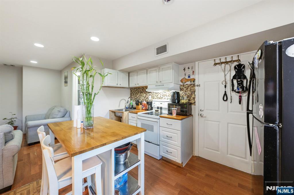 56 Lentz Avenue Newark, NJ 07105 - Photo 45 of 50 a kitchen with stainless steel appliances granite countertop a refrigerator a sink dishwasher and white cabinets with wooden floor