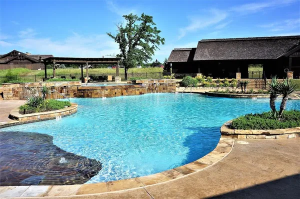 a view of a swimming pool with a patio and plants