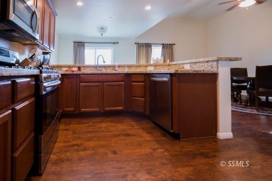 1609 South McCall Street Ridgecrest, CA 93555 - Photo 13 of 33 a kitchen with stainless steel appliances granite countertop a stove a sink and a refrigerator