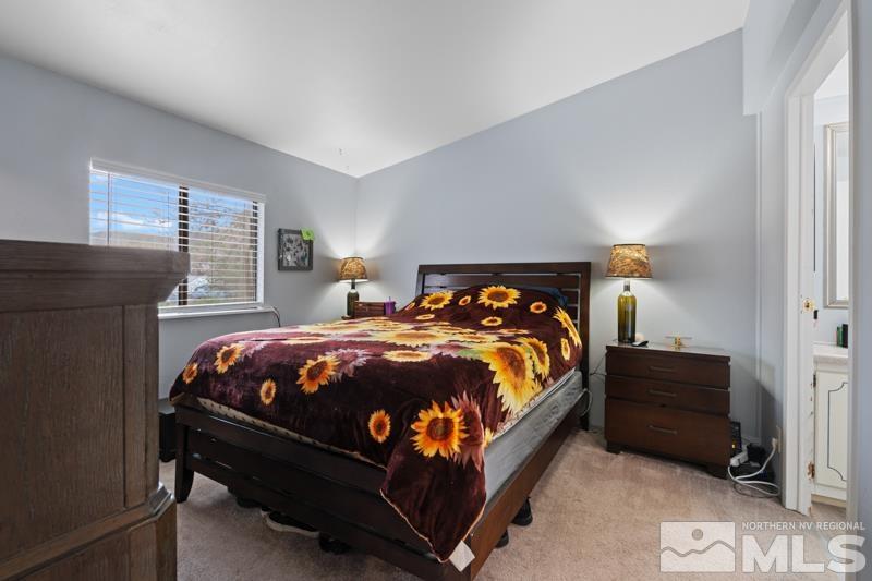 3885 Puffin Street Reno, NV 89508 - Photo 9 of 18 a bed sitting in a bedroom next to a window and a lamp