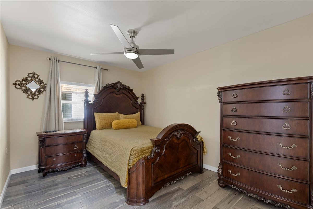 240 Riddle Road Cedar Creek, TX 78612 - Photo 16 of 31 a bedroom with a bed a lamp and a dresser