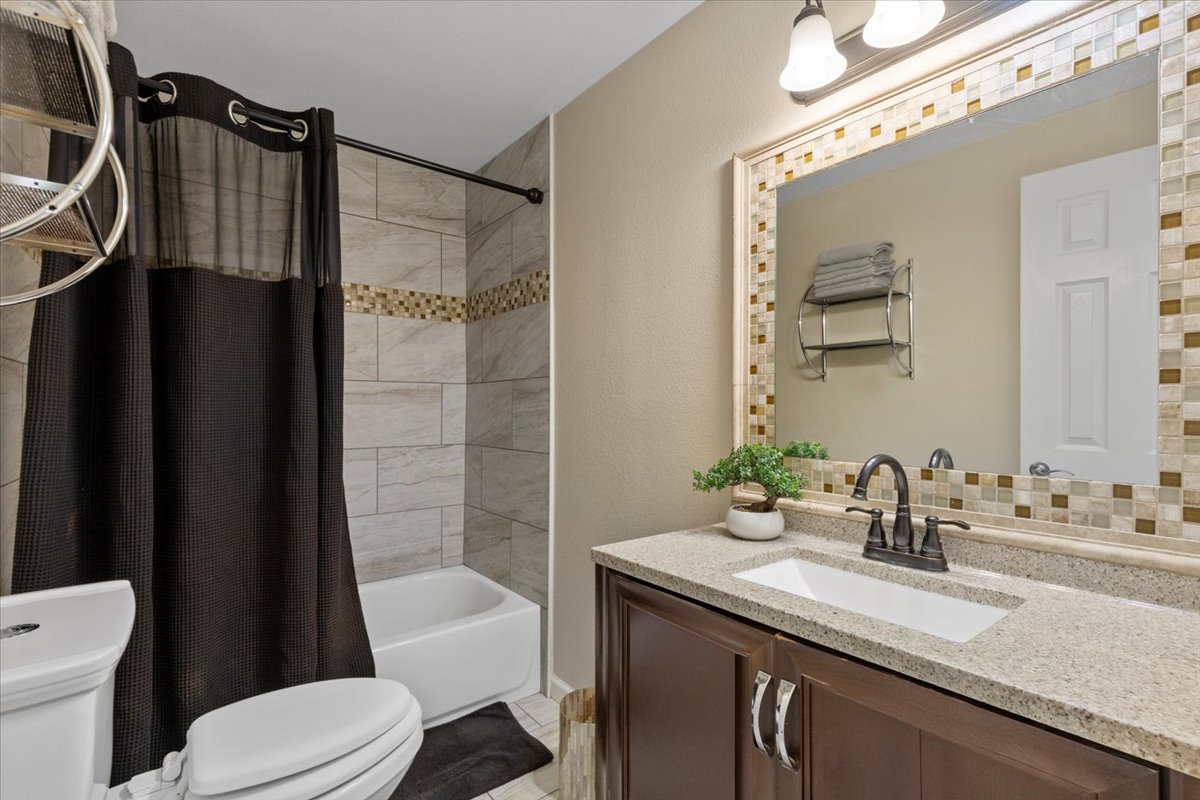 240 Riddle Road Cedar Creek, TX 78612 - Photo 20 of 31 a bathroom with a granite countertop sink toilet and shower