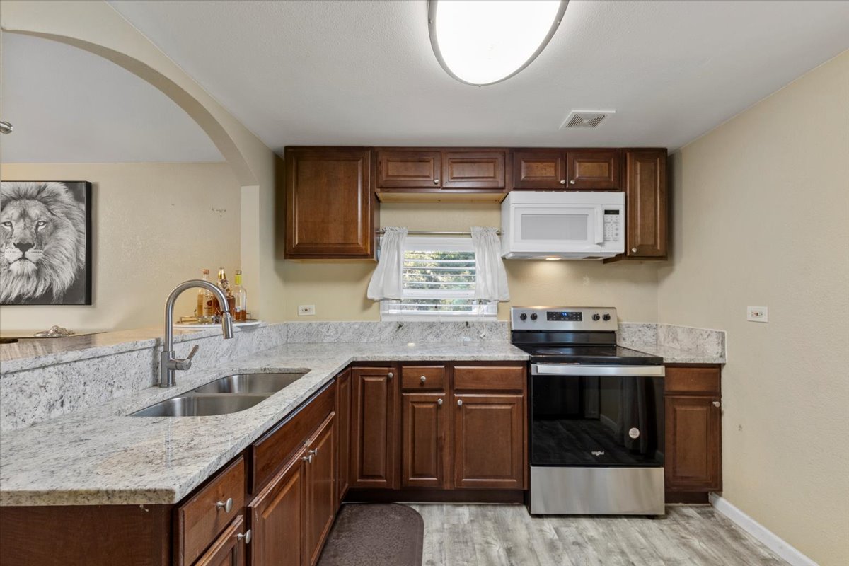 240 Riddle Road Cedar Creek, TX 78612 - Photo 8 of 31 a kitchen with stainless steel appliances granite countertop a sink stove and cabinets
