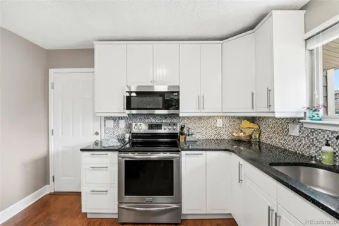 a kitchen with white cabinets and stainless steel appliances