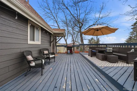 a view of a roof deck with table and chairs under an umbrella