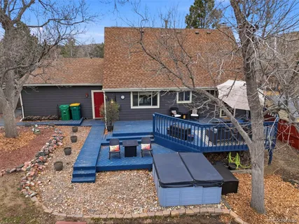 a view of house with wooden deck and furniture