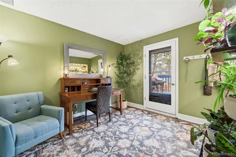 a living room with furniture a potted plant and a window