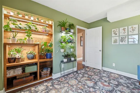 a room with painting on the wall and a potted plant