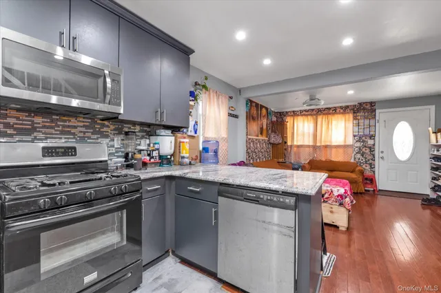 a kitchen with stainless steel appliances granite countertop a stove a sink and a microwave