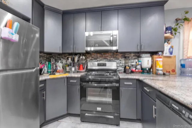 a kitchen with stainless steel appliances granite countertop a refrigerator stove and sink