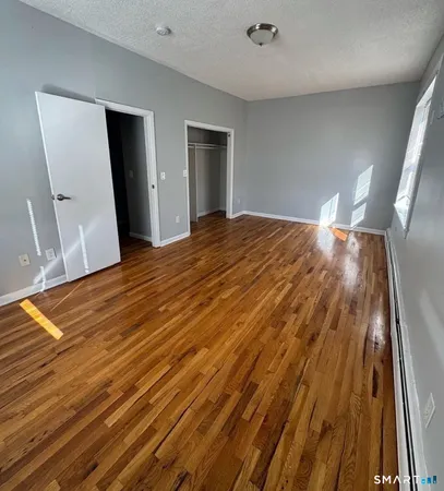 a view of empty room with wooden floor