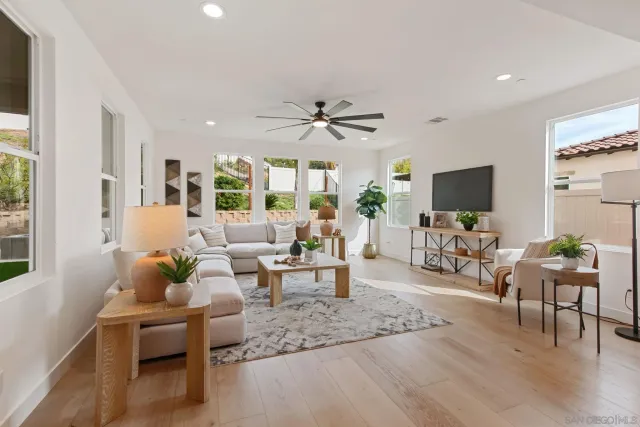 a living room with furniture or chandelier and a wooden floor