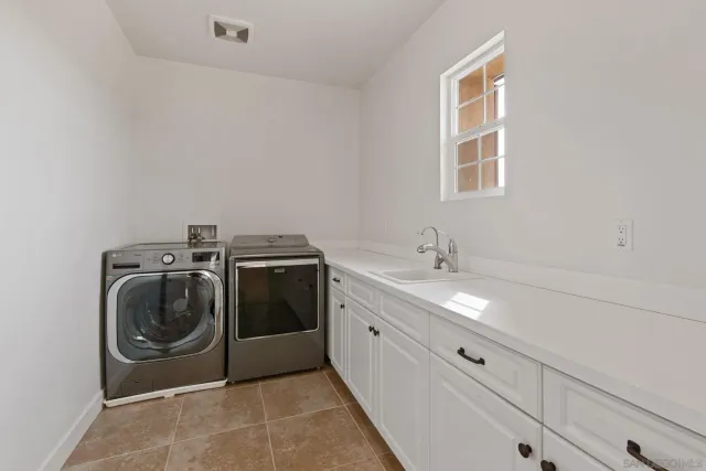 a utility room with sink dryer and washer