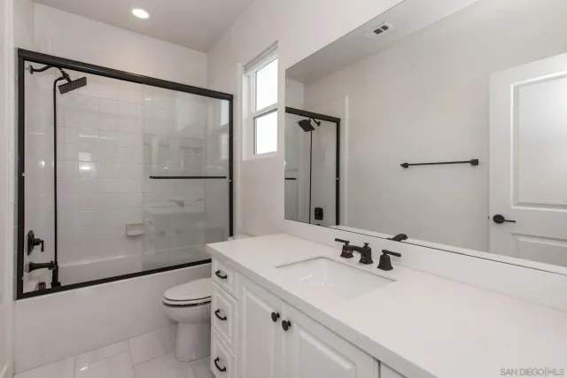 a bathroom with a sink mirror toilet and shower